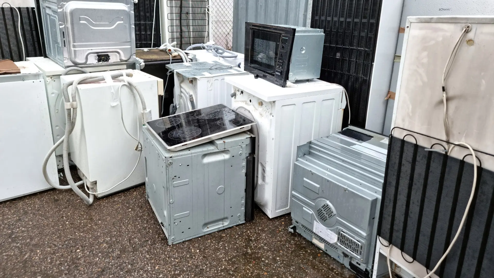 Multiple appliances of different types in very bad shape, located on the outside.