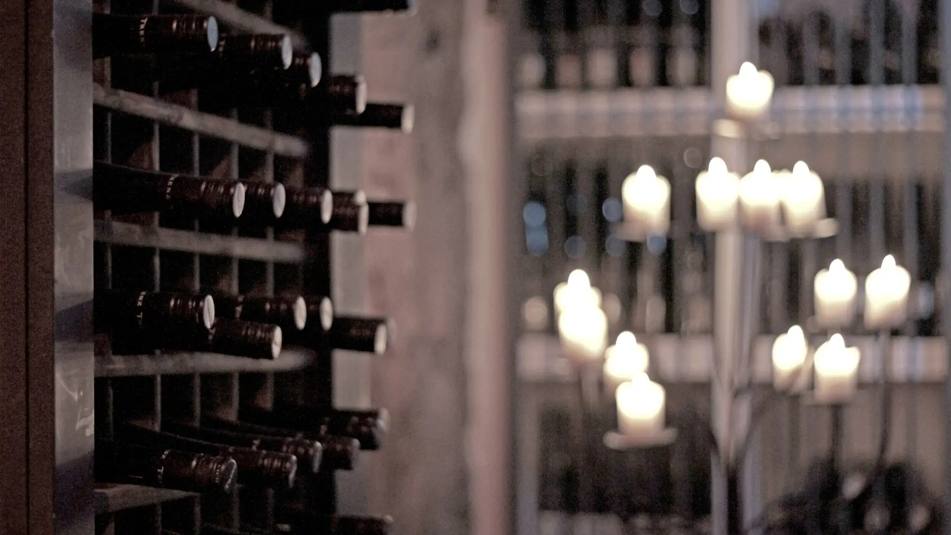 A dark wine cellar filled with wine bottles.